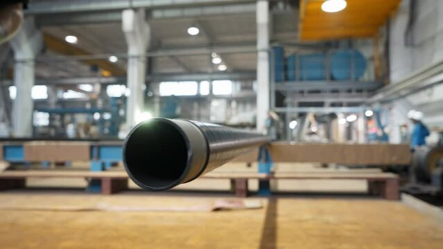 Production process of the heavy steel pipe at the modern manufacturing plant. Close-up of the heavy steel pipe on the conveyor line. Making the heavy steel pipe from the metal material. Factory.