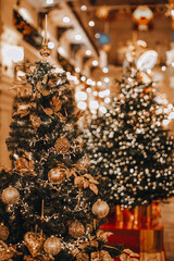 Golden Christmas trees decorated with glittering garland and Christmas balls. Magic indoor details, festive background