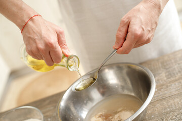 Young man kneading dough on wooden table. Males hands making bread on the kitchen. Baking concept.