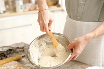 Young man kneading dough on wooden table. Males hands making bread on the kitchen. Baking concept.