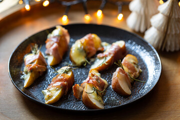 Christmas canapes made of pears, blue cheese and parma ham