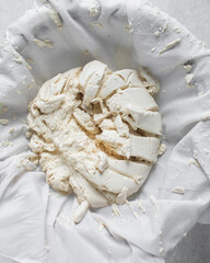 Greek yogurt being strained in white cotton cloth, process of making Greek yogurt, strained yogurt in white cotton napkin