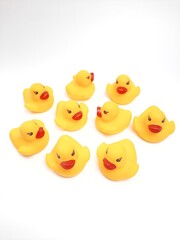 A yellow rubber duck toy isolated on a white background. Gathering rubber ducks