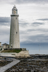 St. Mary's Lighthouse with a large offshore windmill, turbines for alternative green, renewable energy, electricity, just of the English coast. Whitley Bay, Newcastle, UK