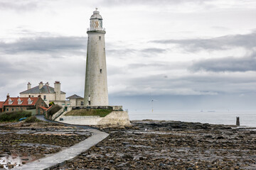 Obraz premium St. Mary's Lighthouse with a large offshore windmill, turbine for alternative green, renewable energy, electricity, just of the English coast. Whitley Bay, Newcastle, UK