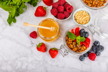 Bowl of granola with yogurt and fresh berries on a texture table. Yogurt berries, acai bowl, spirulina bowl. Healthy food, balanced breakfast. Strawberries, blueberries, kiwi, peach, almonds and chia.