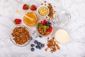 Bowl of granola with yogurt and fresh berries on a texture table. Yogurt berries, acai bowl, spirulina bowl. Healthy food, balanced breakfast. Strawberries, blueberries, kiwi, peach, almonds and chia.