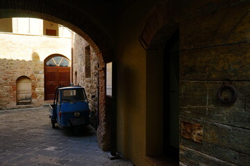 Old car in a desolated builiding of a Tuscany village, Italy
