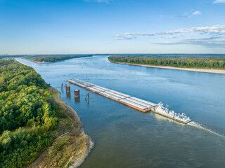 Fototapeta na wymiar towboat with barges on the Mississippi River is entering Chain of Rocks Bypass Canal above St Louis