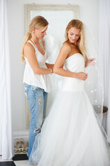 Naklejka premium Wedding, dress and bride with girl friend in a luxury boutique, shop or store in a mall. Retail, romance and female person from Canada preparing for marriage ceremony, party or reception for love.