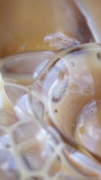 Ice latte with lactose-free milk oat or banana almond coconut milk in a delicious sweet drink close-up macro photography stir add ice. several videos