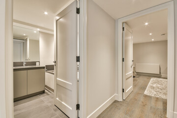 the inside of a house with wood flooring and white trim on the walls, doors open to reveal an empty bathroom