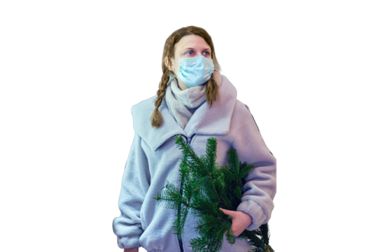 A woman in a medical face mask with a Christmas tree in her hands looks at a shop window with New Year gifts, isolated on a white background