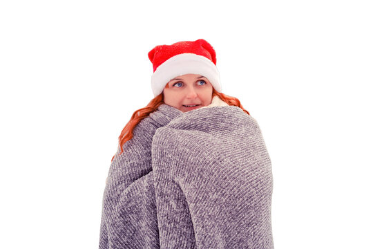 Woman in a Christmas hat wrapped herself in a gray plaid against a background of snow-covered fir trees in a winter park, isolated on a white background