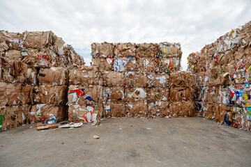 bundled stacks of old waste paper collected for recycling in front of a recycling plant