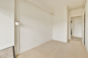 an empty room with white walls and carpeted floor, there is a mirror on the wall in the corner