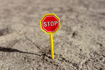 Toy STOP sign on the sand. STOP road sign in a children's sandbox