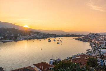 Fototapeta premium Poros, Greece - 17 February 2023 - Overview of the town of Poros on Poros Island and Galatas on the mainland at sunset