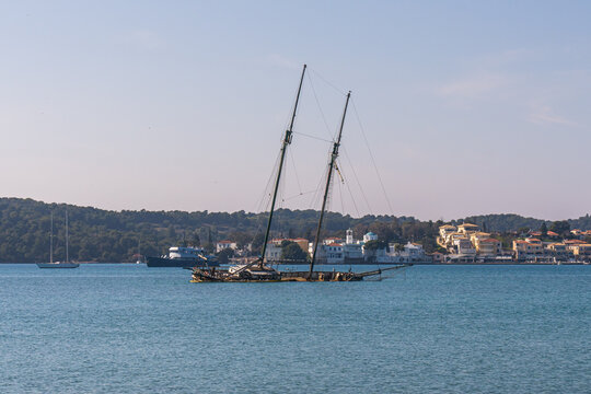 Porto Heli, Greece - 16 February 2023 - Old half sunken sailingboat in the harbour