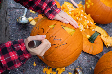 For Halloween, a face is cut into an orange pumpkin with a knive