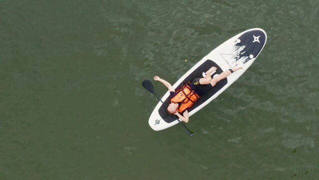 Bashkortostan, Pavlovskoye reservoir. A group of SUP surfers is floating on a boards. Aerial view.