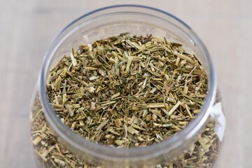 A closeup portrait of dried loose fresh viola tricolor leaves to set a fresh cup of tea in a plastic pot or jar. The herbs are ready to be used in a relaxing warm beverage for some zen time.