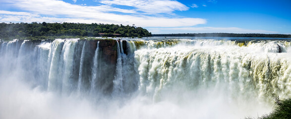 Panorama of Devil's Throat of Iguazu (Iguacu) waterfall, amazing cascade falls landscape in Argentina. Majestic powerful natural waterfalls, summer sunny day. World nature concept. Copy ad text space