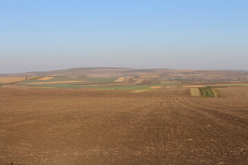 Fototapeta na wymiar A flat plain with a large field and a blue sky
