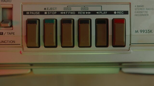 Hand Pressing Stop Button, Inserting Audio Cassette Into Retro Tape Player, Then Pushing Play Button To Turn On Music In Room With Colorful Neon Light. Top Down, Zoom Shot, Close-up View