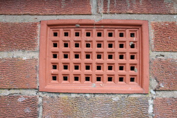 Brick wall with a close up showing a ventilation brick