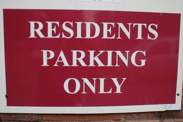 Red and white plastic sign "Residents parking only"