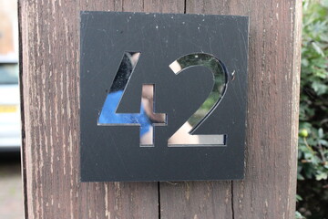 Door number 42 black background and silver reflective surface