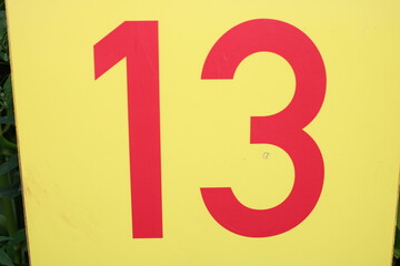 Number 13 red text on a yellow sign