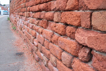 Deteriorating brick wall due to surface water from road traffic UK
