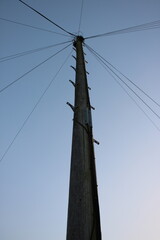 High angle shot of a Telegraph pole cables and foot grips visible, clear sky in background