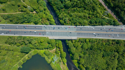 traffic on the highway. Heavy traffic after work on lakeside highway at sunset. Public transport and train passing over train tracks