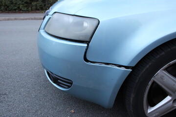 Blue car with a loose bumper, damaged car