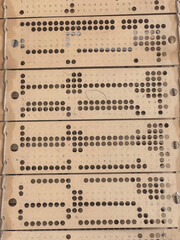 Close up view of punched cards on old working jacquard industrial weaving loom.