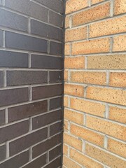 Two different coloured brick walls black brick and a sand coloured brick angled shot