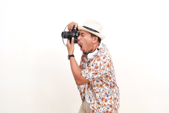 Wow Excited Asian man traveler taking images photo with camera. Isolated on white background with copyspace