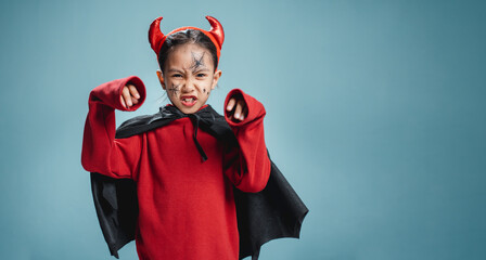 A little girl is wearing a witch costume for Halloween.