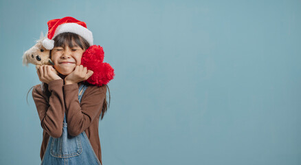 A little girl is wearing a Christmas hat, is happy to join the Christmas day.
