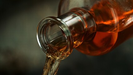 Bottle of Whiskey with Pouring Liquid.