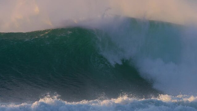 huge powerful wave crashing in the ocean in slow motion