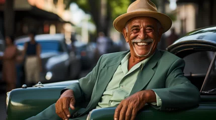 Poster Cuban driver in Havana, with his colored suit, and his car from the 50s, enjoying touring the city with tourists, Cuban life, Caribbean lifestyle © Juan Gumin