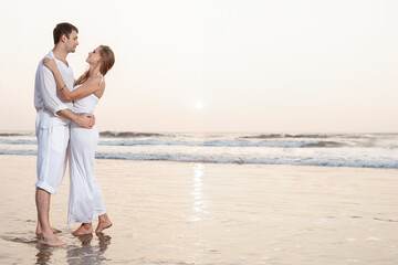 Happy Romantic Young Couple Enjoying Beautiful Sunset on the Beach