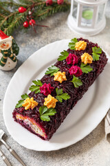 Festive layered shuba salad. Traditional Russian Christmas New Year vegetable salad roll with herring and boiled vegetables.