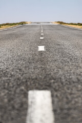 Car asphalt road in the middle of the hot empty Kazakh steppe, asphalt texture on the highway