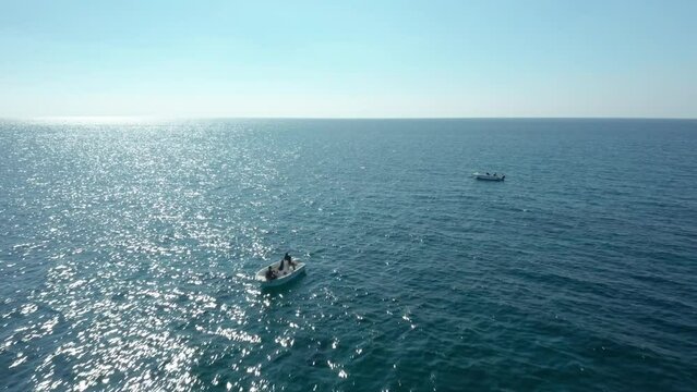 Overflight of two boats in the open sea, with fishermen on board