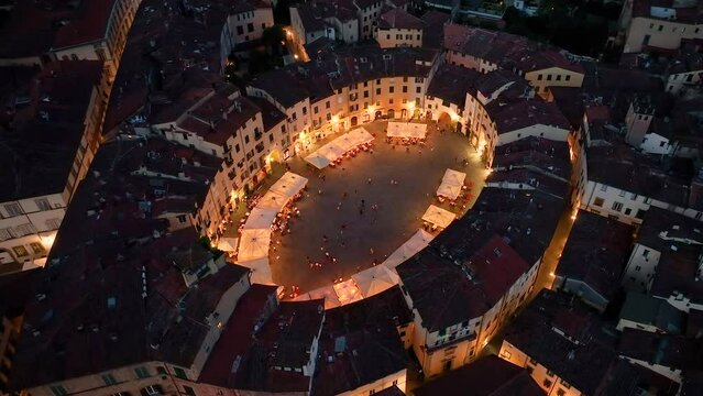Illuminated Piazza dell'Anfiteatro, Lucca aerial view, Tuscany, Italy